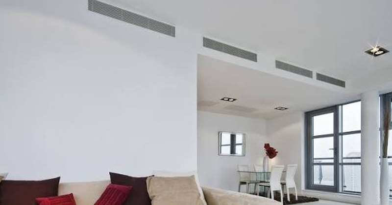 Grilles de soufflage d'une climatisation gainable intégrées au plafond d'un séjour